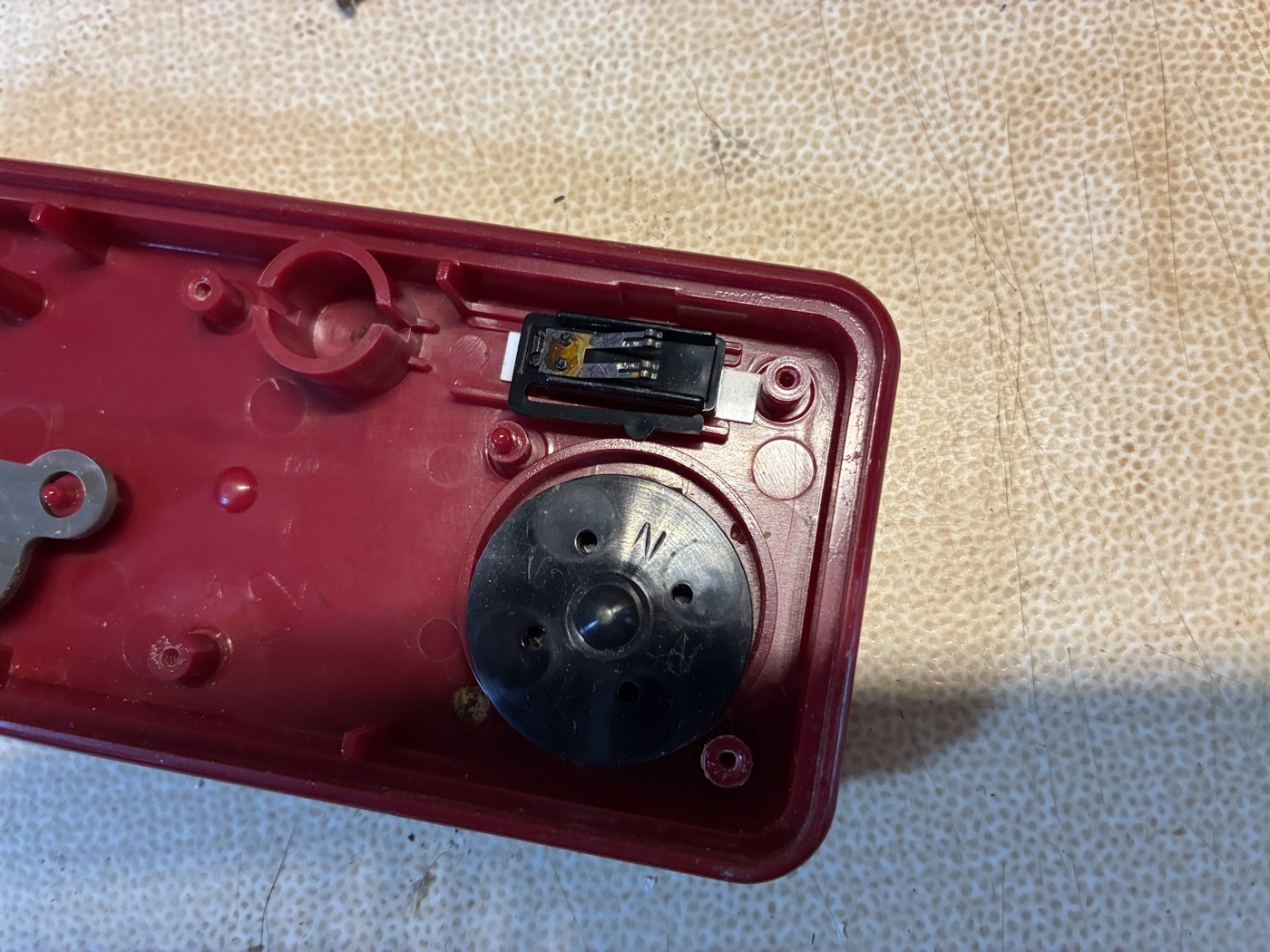 The slide switch seated beside the microphone element inside the shell